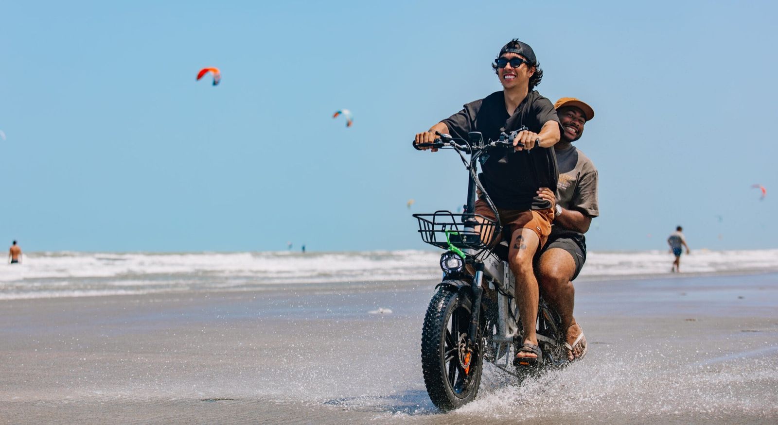 Casal andando de bicicleta elétrica Bici Eletric na praia